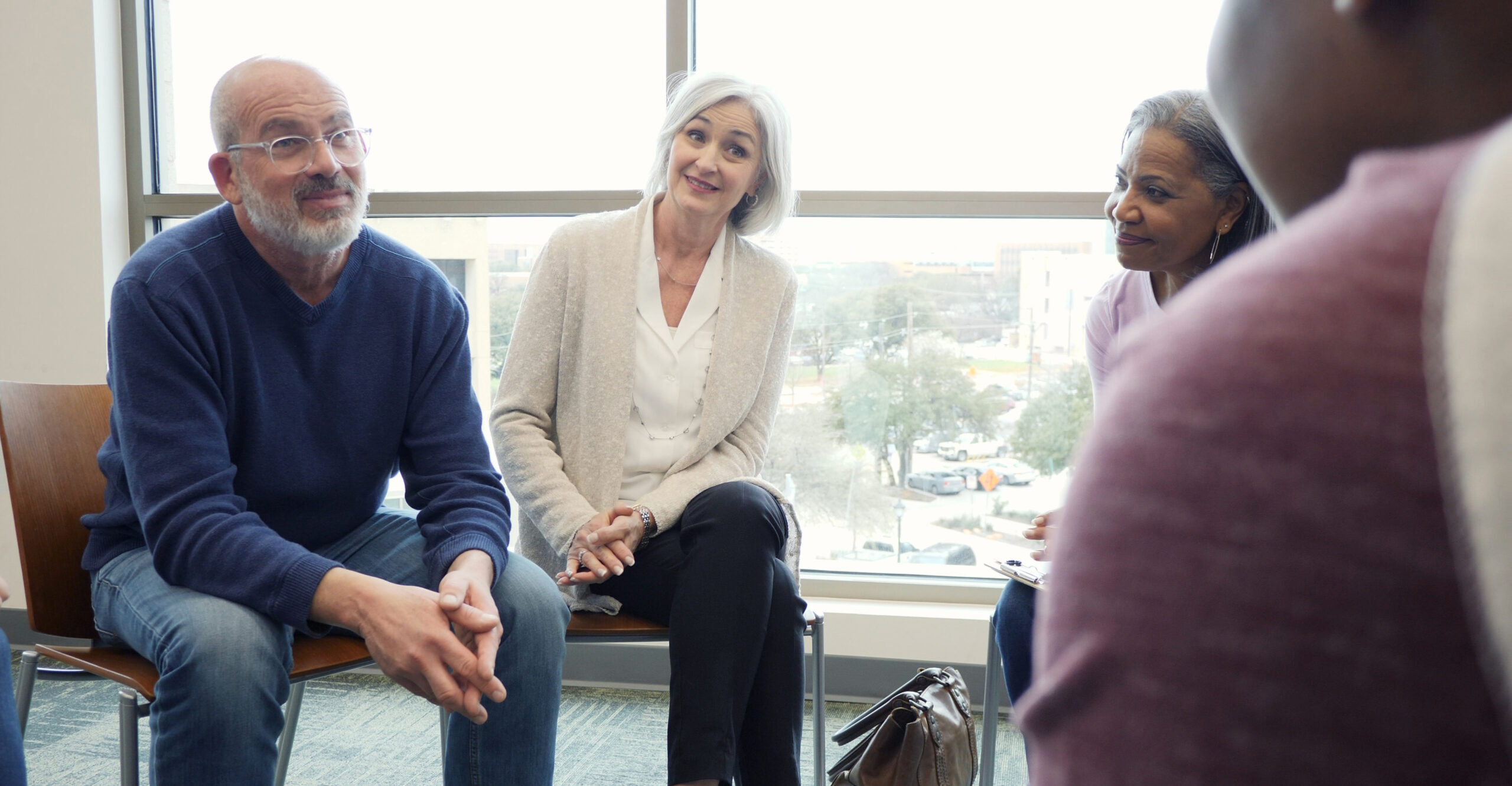 As the teen responds, the mature adult members of the addiction support and therapy group listen attentively.